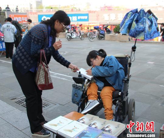 洛洛正在給買書的顧客簽名。 馮曉林 攝